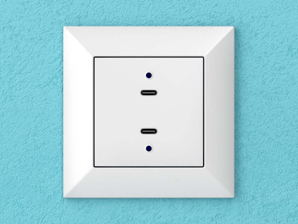 A white wall socket with two USB-C ports, set against a textured light blue wall. This modern, square USB power point features blue indicator lights next to each port for a sleek and functional upgrade to any space.